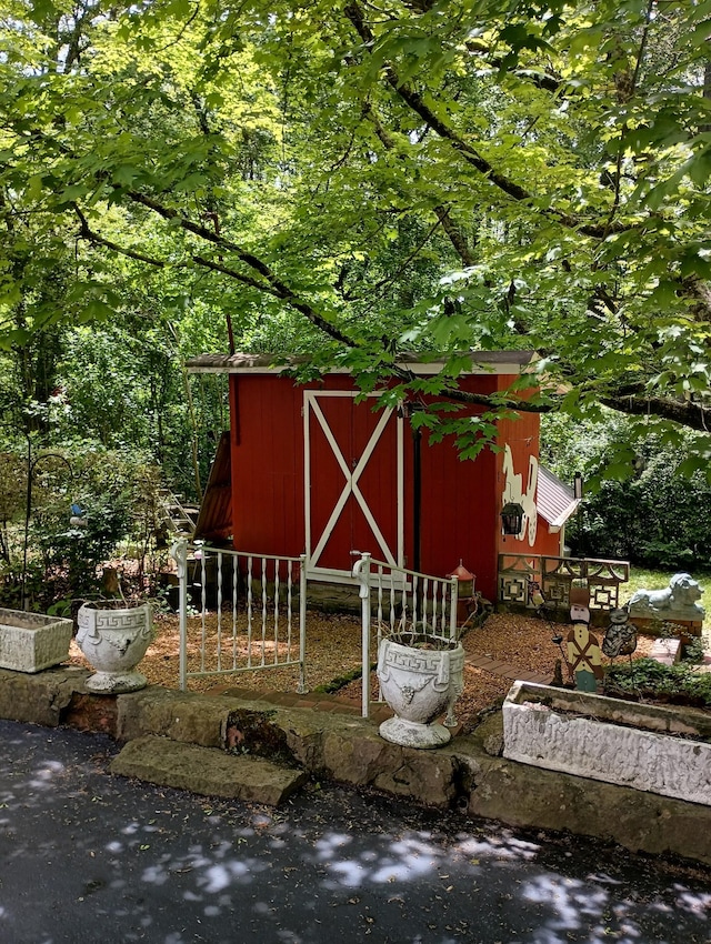 view of outbuilding featuring fence and an outbuilding