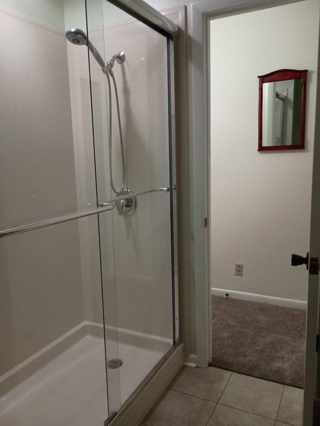 full bath with tile patterned floors, baseboards, and a stall shower