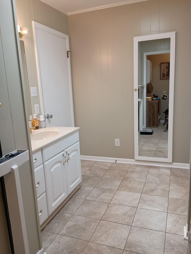 bathroom featuring tile patterned floors, ornamental molding, baseboards, and vanity
