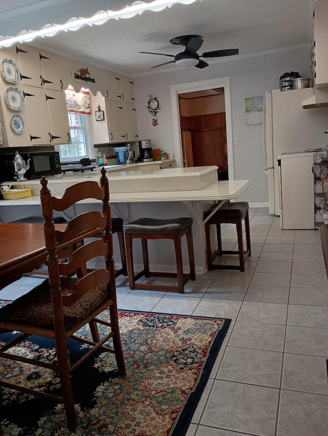 dining space featuring crown molding, a ceiling fan, and light tile patterned floors