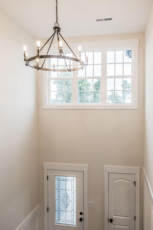 doorway to outside featuring a chandelier and visible vents