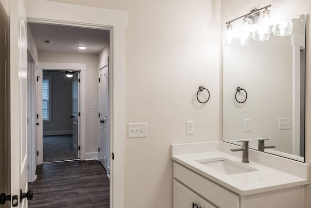 bathroom with baseboards, wood finished floors, and vanity