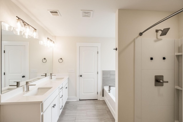 bathroom featuring visible vents, a sink, a tub, and double vanity