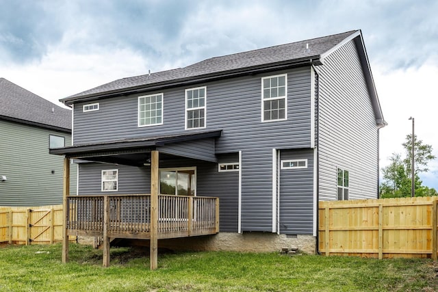 rear view of property with fence and a deck
