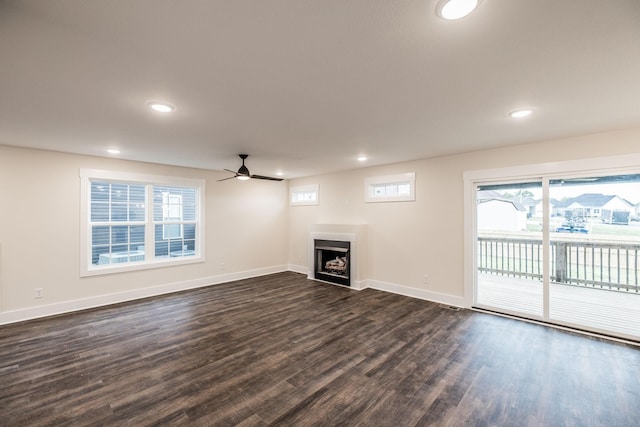 unfurnished living room featuring baseboards, a ceiling fan, dark wood-style flooring, and recessed lighting