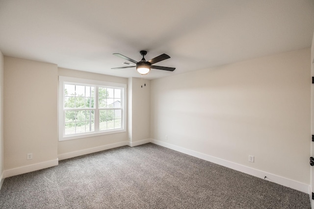 carpeted spare room featuring ceiling fan and baseboards