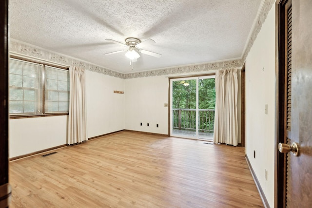 spare room with ornamental molding, light wood finished floors, ceiling fan, and a textured ceiling