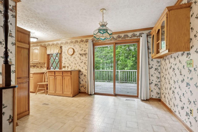 dining area featuring wallpapered walls, ornamental molding, and a healthy amount of sunlight