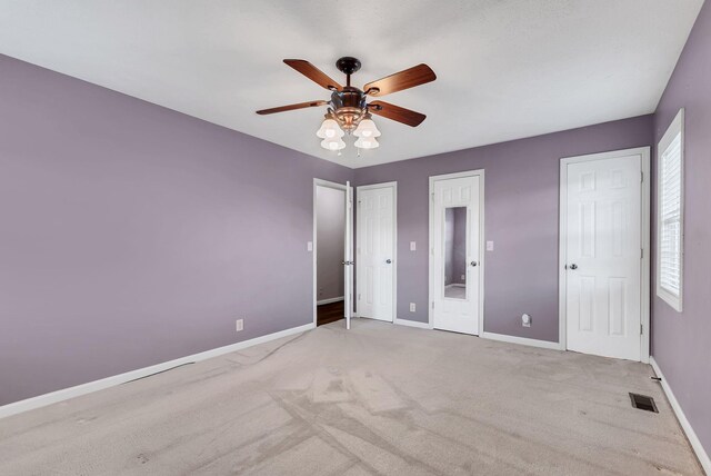 210 Edgewood Dr, Hohenwald, TN 38462 - unfurnished bedroom featuring baseboards, carpet flooring, multiple closets, and visible vents