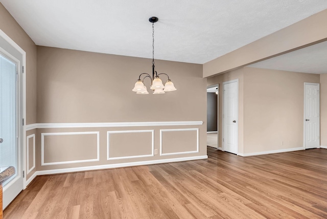 210 Edgewood Dr, Hohenwald, TN 38462 - spare room with light wood-style floors, baseboards, and an inviting chandelier
