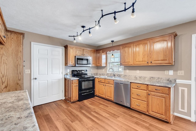 210 Edgewood Dr, Hohenwald, TN 38462 - kitchen with light countertops, stainless steel appliances, a sink, and light wood-style floors