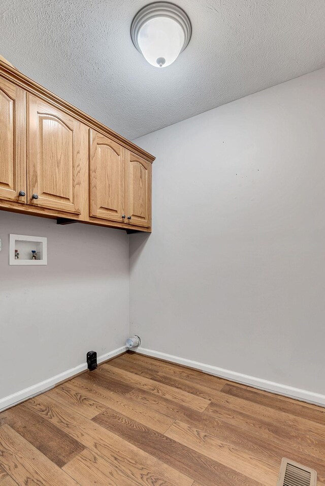 210 Edgewood Dr, Hohenwald, TN 38462 - laundry area with visible vents, wood finished floors, baseboards, hookup for a washing machine, and cabinet space