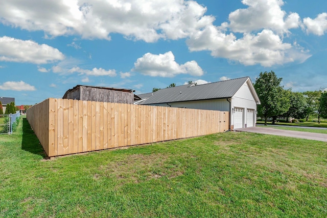 210 Edgewood Dr, Hohenwald, TN 38462 - view of side of home with fence, a yard, metal roof, and a garage