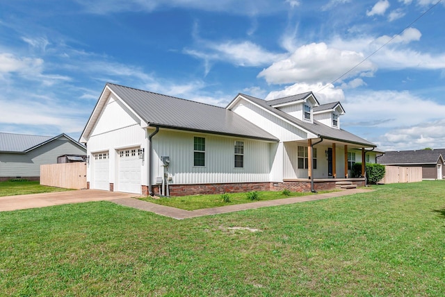 210 Edgewood Dr, Hohenwald, TN 38462 - view of front facade with a garage, concrete driveway, a front yard, metal roof, and a porch