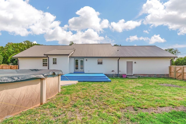 210 Edgewood Dr, Hohenwald, TN 38462 - back of house featuring fence, a fenced in pool, french doors, a lawn, and metal roof