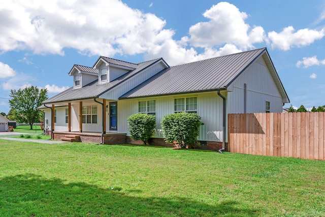 210 Edgewood Dr, Hohenwald, TN 38462 - view of front facade featuring fence, covered porch, metal roof, and a front yard