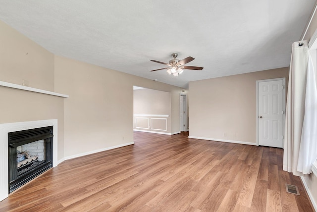 210 Edgewood Dr, Hohenwald, TN 38462 - unfurnished living room featuring ceiling fan, visible vents, a fireplace, baseboards, and light wood-style flooring