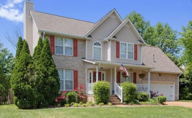 2011 Spring Meadow Cir, Spring Hill, TN 37174 - view of front of home featuring covered porch, a chimney, brick siding, an attached garage, and concrete driveway