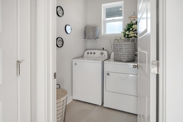 clothes washing area featuring laundry area, independent washer and dryer, and light tile patterned floors