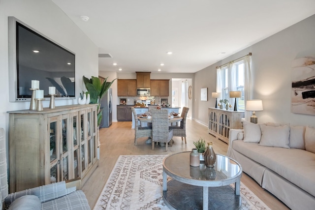 living area featuring recessed lighting, light wood finished floors, and baseboards