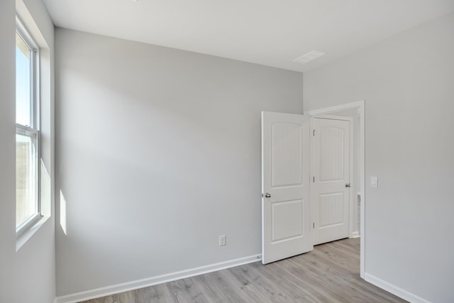unfurnished room with baseboards and light wood-type flooring