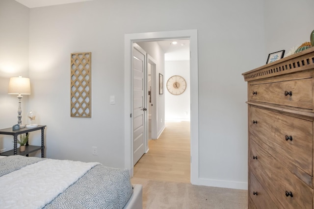 bedroom with baseboards and light carpet