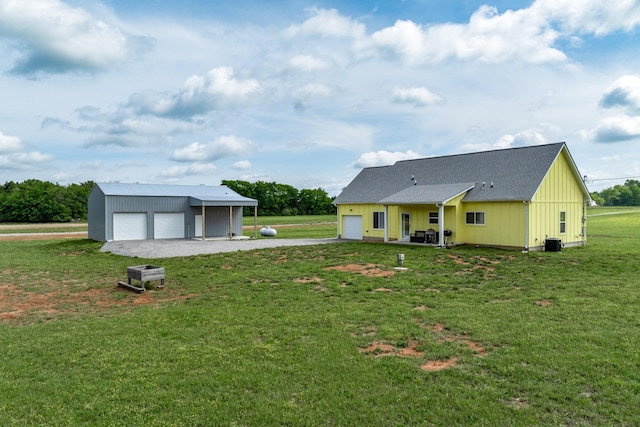 1317 Halls Mill Rd, Unionville, TN 37180 - rear view of house with board and batten siding, a lawn, central AC unit, a garage, and an outdoor structure