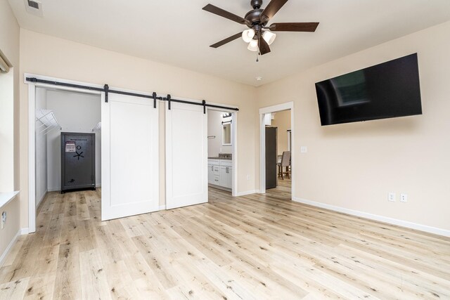 1317 Halls Mill Rd, Unionville, TN 37180 - unfurnished living room featuring a barn door, light wood-style floors, a ceiling fan, baseboards, and visible vents