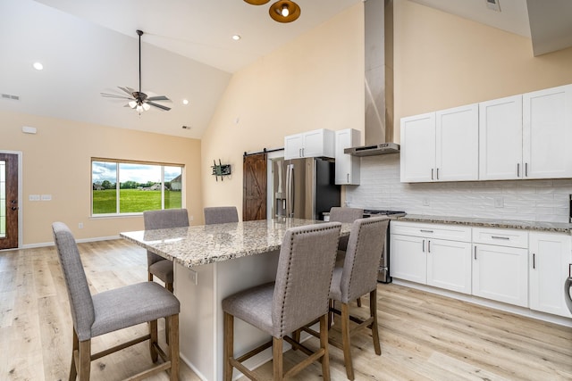 1317 Halls Mill Rd, Unionville, TN 37180 - kitchen featuring a kitchen bar, appliances with stainless steel finishes, a barn door, high vaulted ceiling, and light wood-style flooring