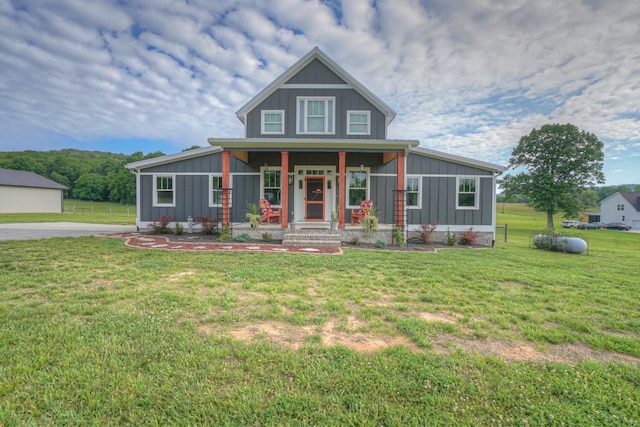 view of front of house featuring board and batten siding, a front yard, and a porch
