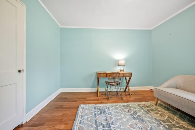 living area with crown molding, baseboards, and wood finished floors
