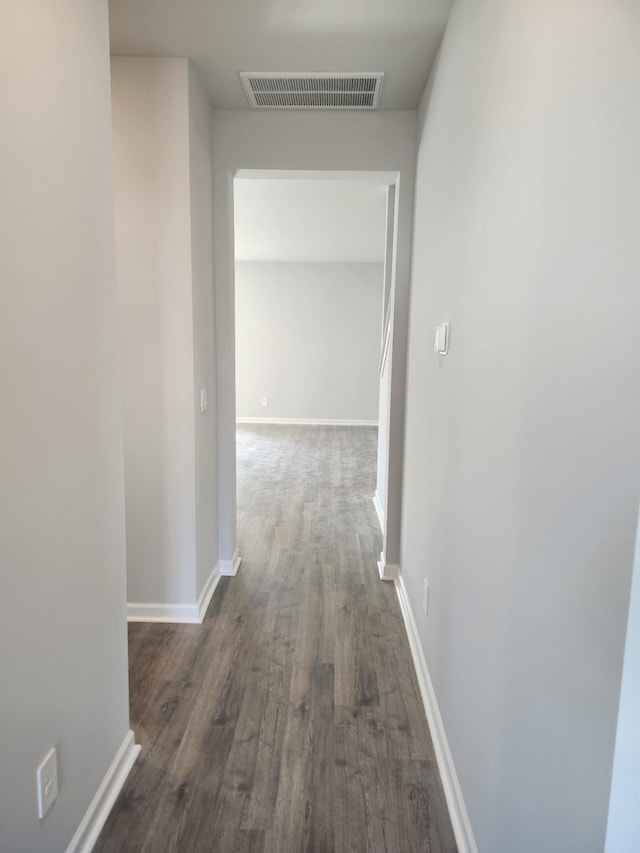 hall with baseboards, dark wood-style floors, and visible vents