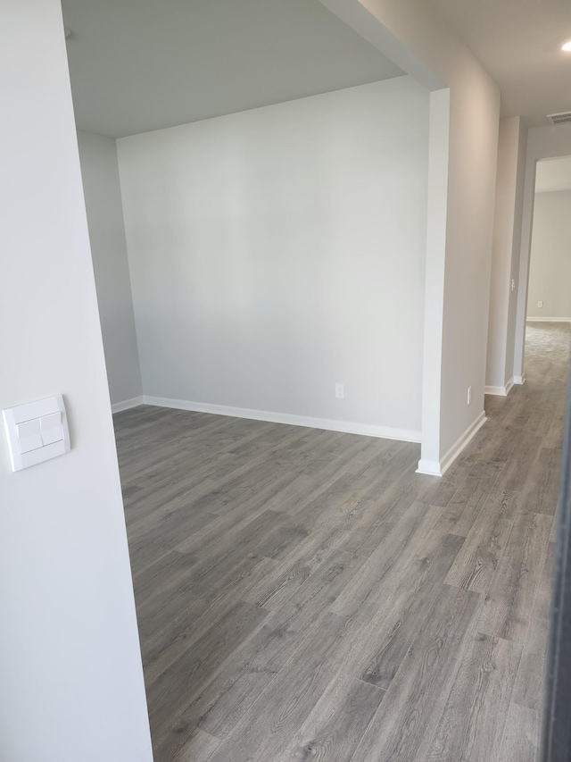 empty room featuring baseboards, recessed lighting, and wood finished floors