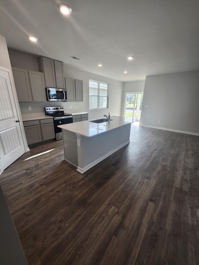 kitchen featuring visible vents, a sink, appliances with stainless steel finishes, and gray cabinetry