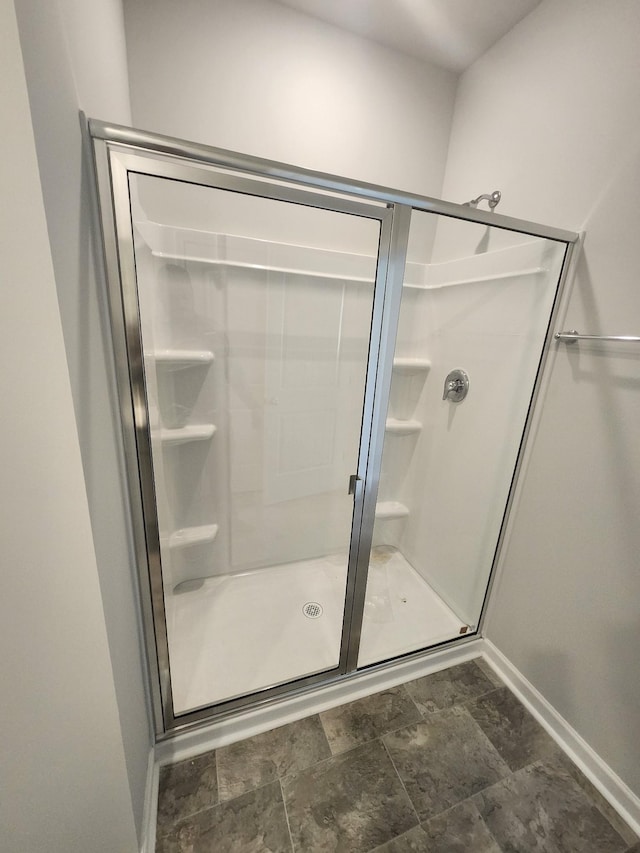 bathroom with baseboards and a stall shower