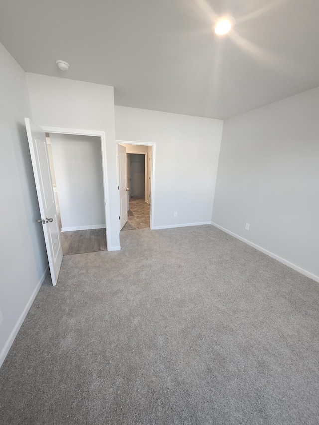 unfurnished bedroom featuring carpet floors and baseboards