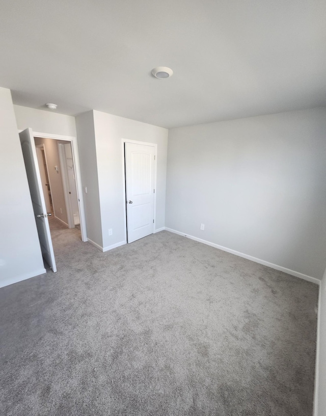 unfurnished bedroom featuring baseboards and carpet
