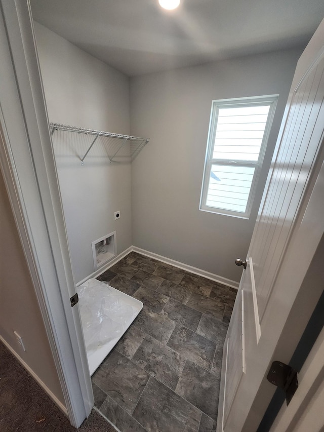 laundry room with laundry area, hookup for a washing machine, stone finish floor, baseboards, and hookup for an electric dryer