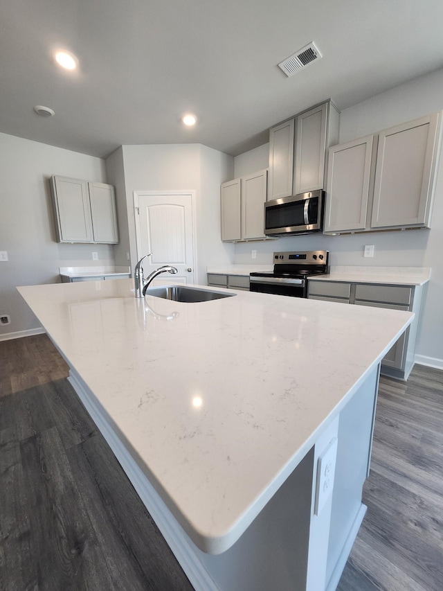 kitchen featuring a sink, gray cabinets, stainless steel appliances, baseboards, and visible vents