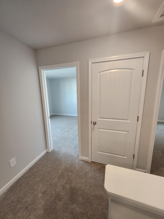 corridor with carpet flooring and baseboards
