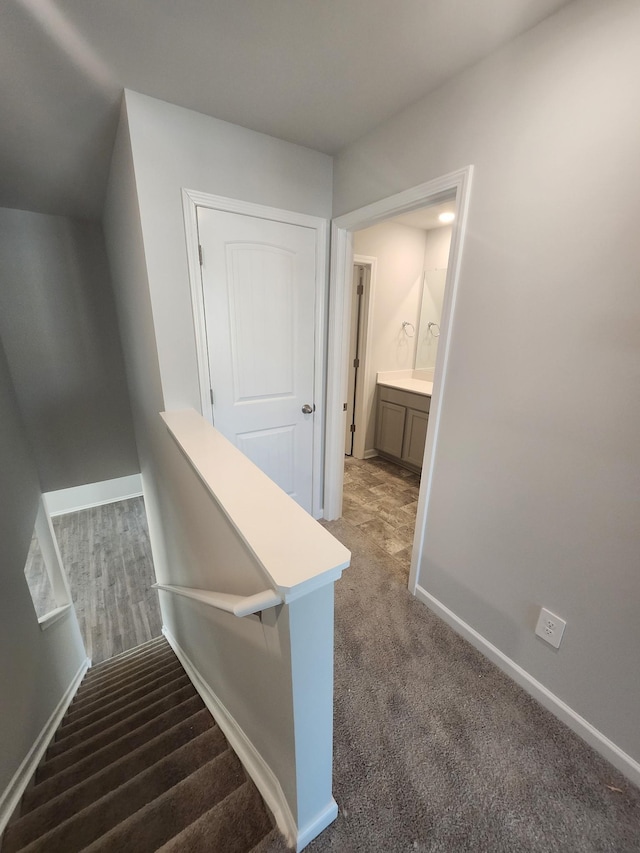 staircase with baseboards and carpet