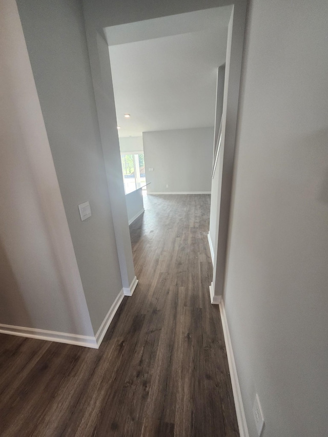 corridor featuring baseboards, recessed lighting, and dark wood-type flooring
