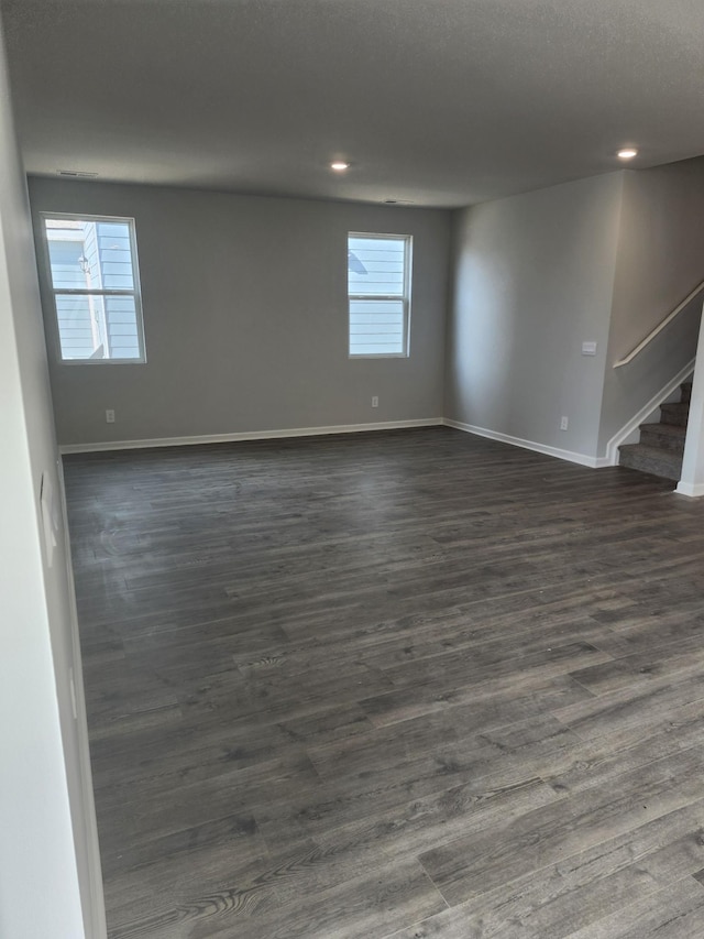 spare room with baseboards, recessed lighting, dark wood-style floors, and stairway