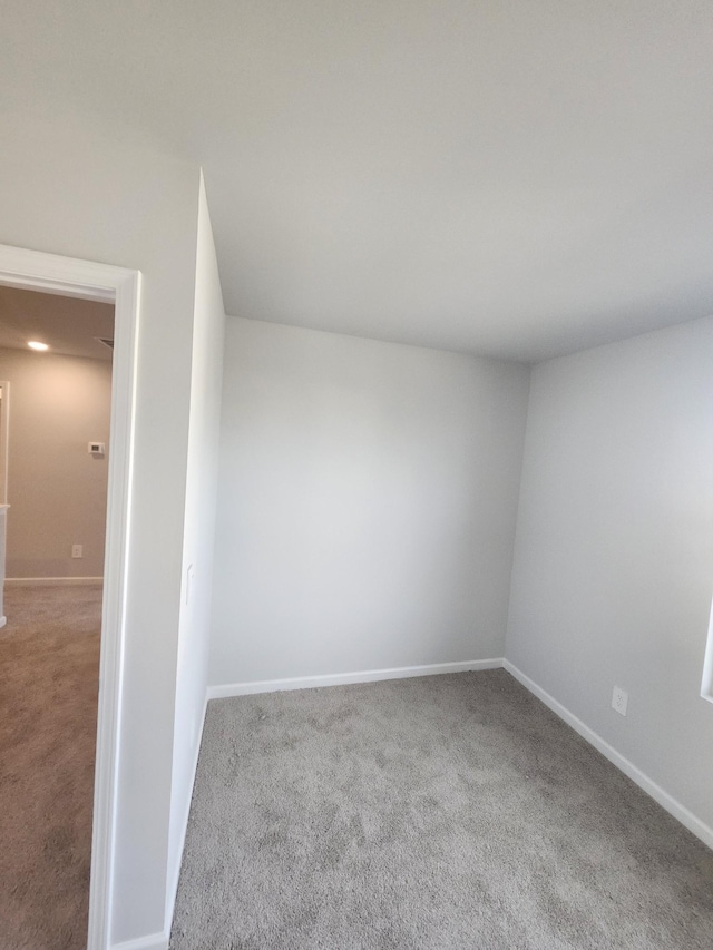 unfurnished room featuring baseboards and carpet flooring