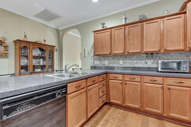 kitchen with visible vents, crown molding, black dishwasher, arched walkways, and a sink