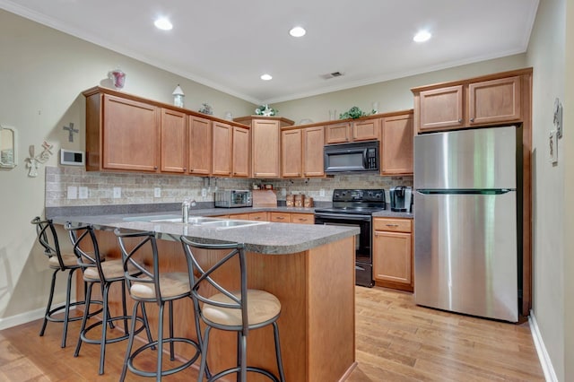 kitchen with a sink, backsplash, black appliances, and a peninsula
