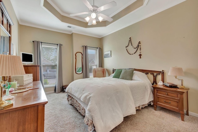 bedroom featuring crown molding, visible vents, baseboards, light colored carpet, and a raised ceiling