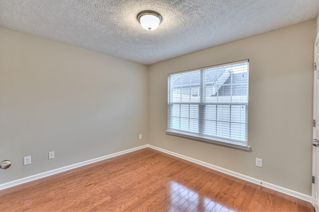 2039 Caladonia Way, Smyrna, TN 37167 - unfurnished room with baseboards, a textured ceiling, wood finished floors, and a healthy amount of sunlight