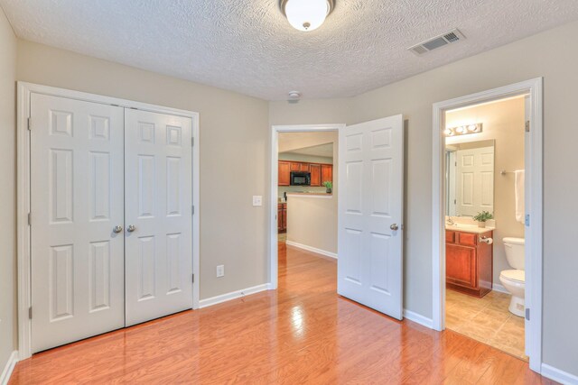 2039 Caladonia Way, Smyrna, TN 37167 - unfurnished bedroom with light wood-style floors, a textured ceiling, ensuite bathroom, visible vents, and a closet
