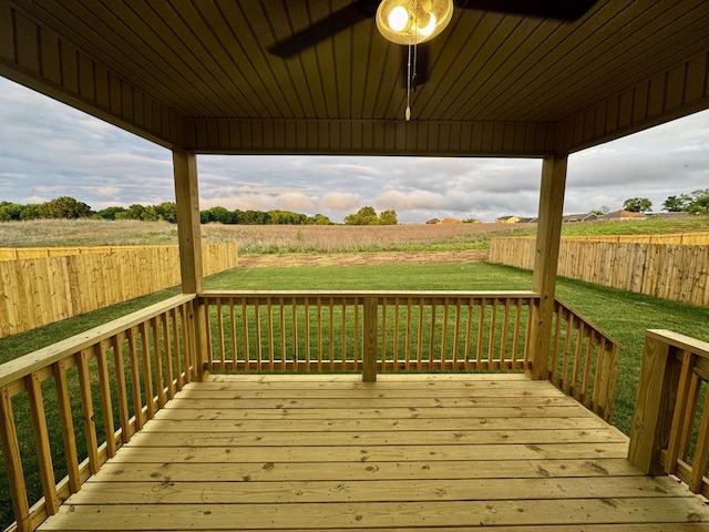 wooden deck with a lawn and fence